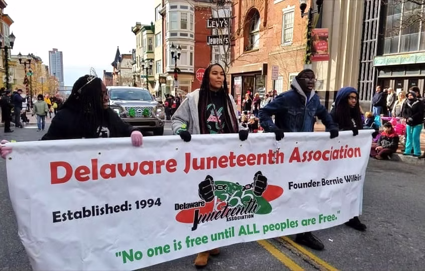 Delaware Juneteenth Association Freedom Parade banner carried through Wilmington